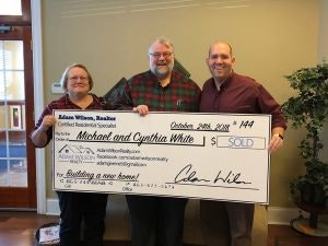HRHS team and happy clients holding a check