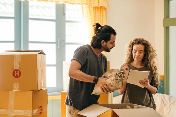 A couple packing moving boxes in their home
